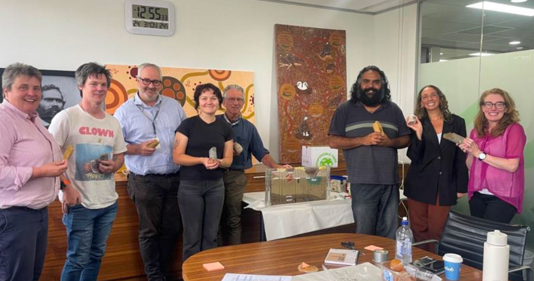 8 staff gathered in an office in line for photo