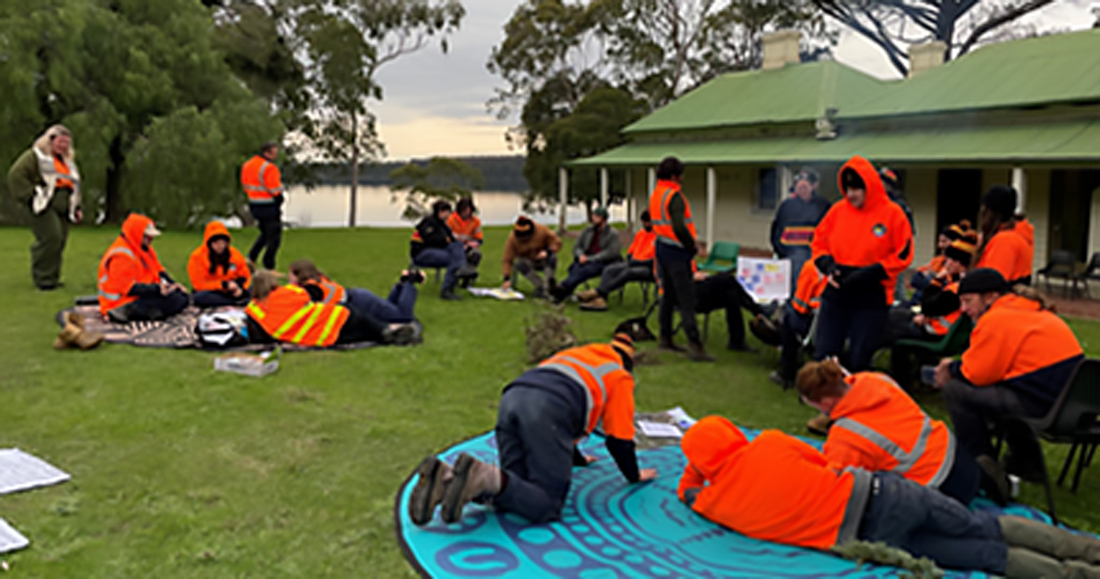 Narrap unit staff gathered around in groups outside on grass and chairs